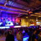 grande salle d'e-sport illuminée avec écrans géants, foule spectateurs cs:go