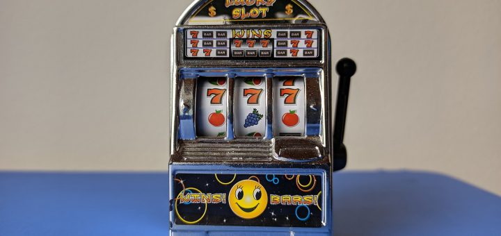 machine à sous vintage avec trois rouleaux affichant des 7 et des fruits