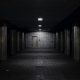 Dark, empty underground tunnel with dim lights and a door.