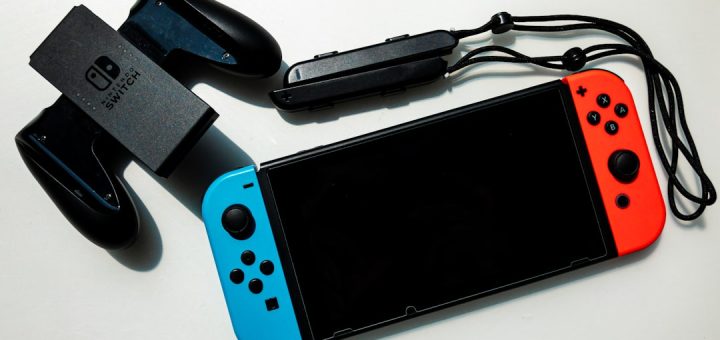 white nintendo switch beside black usb flash drive