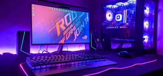 A gaming computer setup with a monitor, keyboard, and tower in purple light